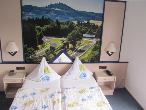 a bedroom with two beds and a view of a mountain at Land-gut-Hotel zur Burg Nürburg in Nürburg