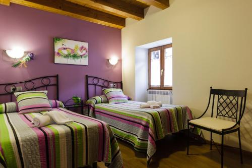 a bedroom with two beds and a chair at Alojamientos Rurales Apezarena in Izalzu