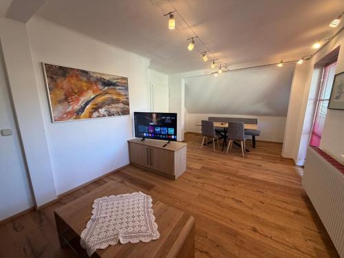 a living room with a table and a painting on the wall at Ferienwohnung Roseggersiedlung in Murau