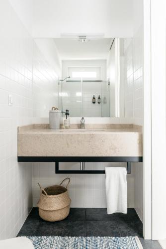 a bathroom with a large sink and a basket at O Lugar in Porto Covo