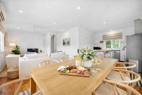 a kitchen and living room with a table with food on it at 4 Bed Queenslander City Views Walk to Suncorp Deck + Parking in Brisbane