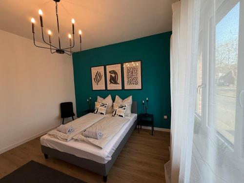 a bedroom with a bed with a green wall at Home&Living - Casa Nova in Meerbusch