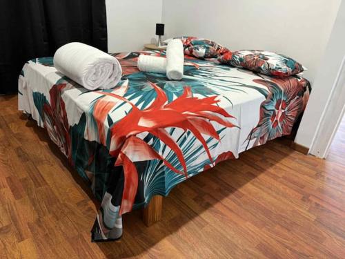 a bed with a colorful blanket and pillows on it at Bungalow Hoarai in Uturoa