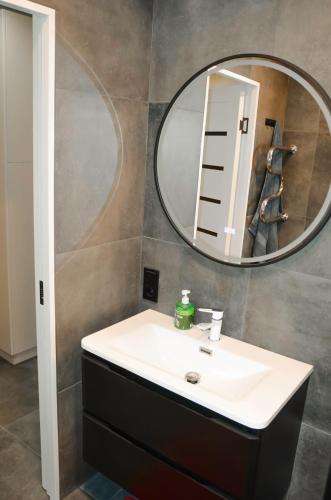 a bathroom with a sink and a mirror at Merķeļa apartamenti in Valka