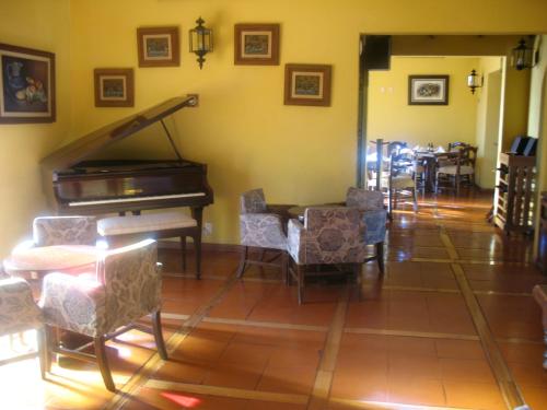 a room with a piano and a table and chairs at Casa Cantarranas in Tehuacán