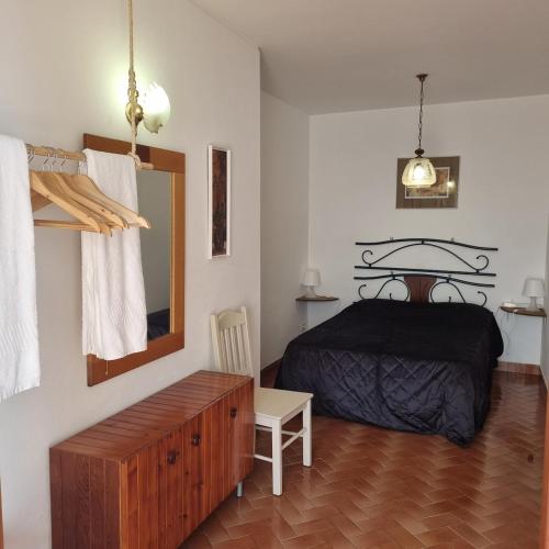 a bedroom with a bed and a dresser and a mirror at Casa Nelinha by Rosado in Luz