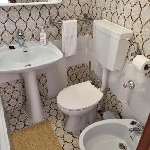 a bathroom with a white toilet and a sink at Casa Nelinha by Rosado in Luz