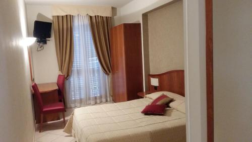 アスティにあるHotel Cavourのベッドルーム1室(ベッド1台、椅子、窓付)