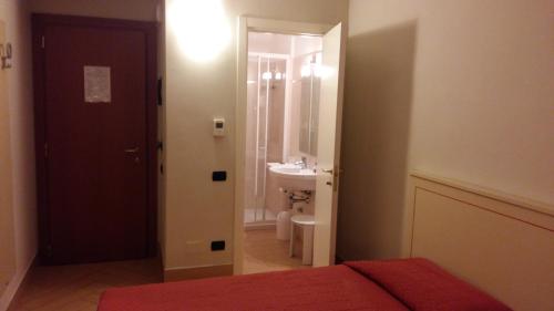 アスティにあるHotel Cavourのベッドルーム1室(ベッド1台付)、バスルーム(シンク付)