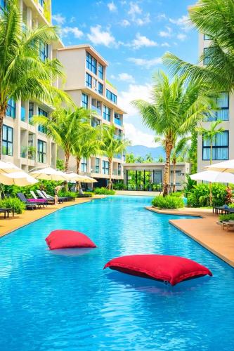 a swimming pool with two red pillows in a resort at Diamond apartaments 700m BangTao beach in Bang Tao Beach