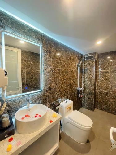 a bathroom with a sink and a toilet and a mirror at Diamond Villa in Hanoi