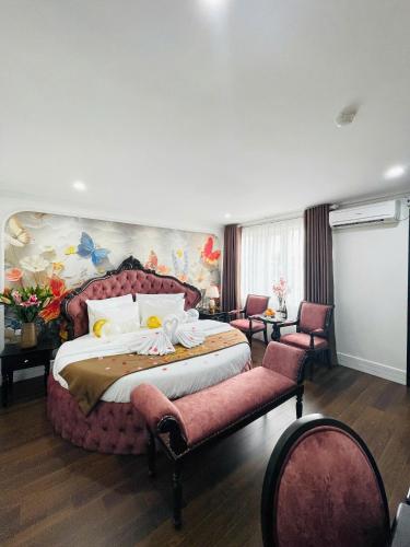 a bedroom with a large bed and two chairs at Diamond Villa in Hanoi