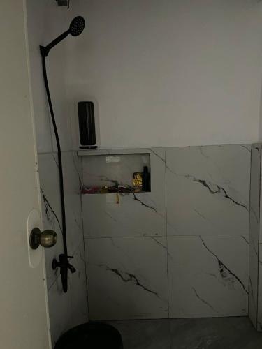 a bathroom with a microphone and a marble wall at Lavish style at Laguna by Nelson in Biñan