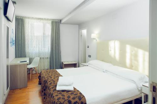 
a hotel room with a bed and a desk at Casual Gurea in Bilbao

