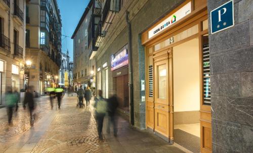 a group of people walking down a street at night at Casual Gurea in Bilbao
