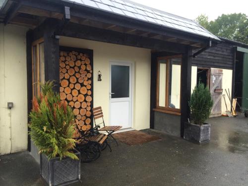 a house with a bunch of logs on the wall at Barton Gate Farm B&B in Bude