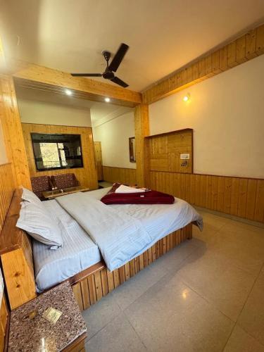 a bedroom with a large bed with a ceiling at Himvilla Kasol in Jāmb