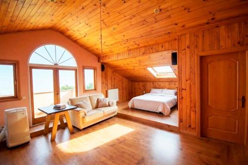 a bedroom with a bed and a couch in a room at Villa la cantera in Guadarrama