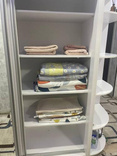 a white closet with some folded items on it at Seven Resedens 82-15 in Sergeli