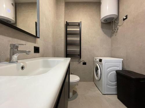 a bathroom with a sink and a washing machine at Luxury Bruchi in Durrës