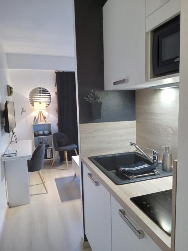 a kitchen with a sink and a desk at Résidence Le poisson d'or in Perros-Guirec