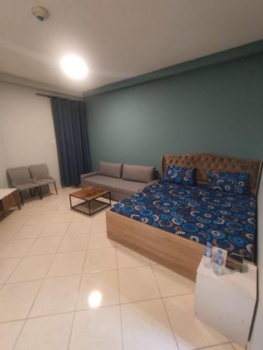 a large bedroom with a bed and a couch at Trendy Studio In Orient Towers Ajman in Ajman 