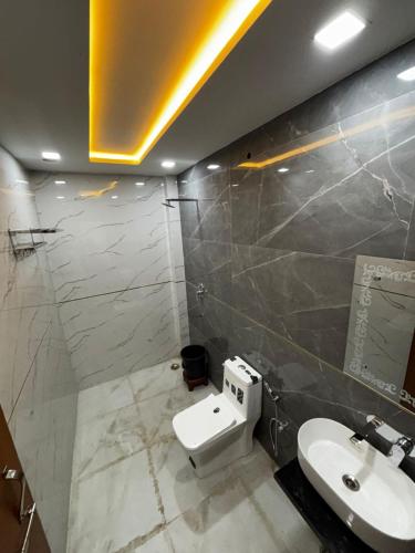 a bathroom with a white toilet and a sink at Hotel MM Palace Vairo Cafe Rooftop View Taj Mahal in Tājganj