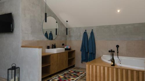 a bathroom with a tub and a sink and a mirror at Avala apartments in Beli Potok