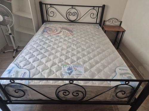 a bed with a metal frame and a mattressvisor at Residence les jardins cap de l eau in Ras El Ma