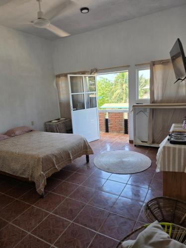 a bedroom with a bed and a tv in a room at Estudio Arena in Brisas de Zicatela