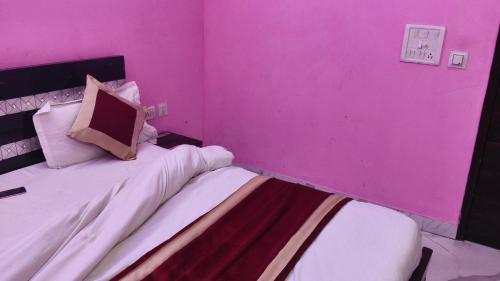 a room with two beds in a pink room at Hotel rishav prime in Ghaziabad