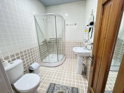 a bathroom with a shower and a toilet and a sink at SHoxtut INN 18-19Th Century in Bukhara