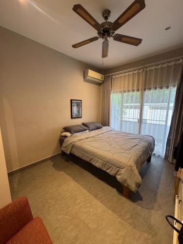 a bedroom with a bed and a ceiling fan at Villa Grace in Ban Pak Khlong Phe