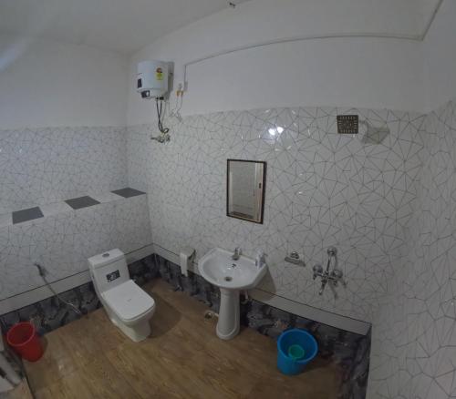 a bathroom with a toilet and a sink at Hobo's Nest in Kurseong
