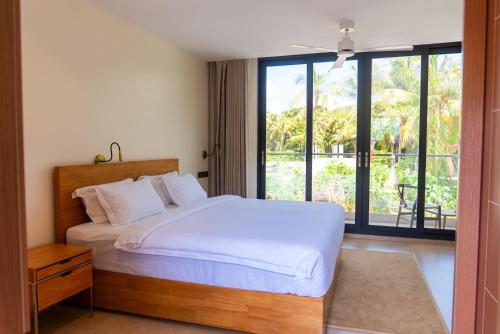 a bedroom with a bed and a view of a patio at Aire Dharavandhoo in Dharavandhoo