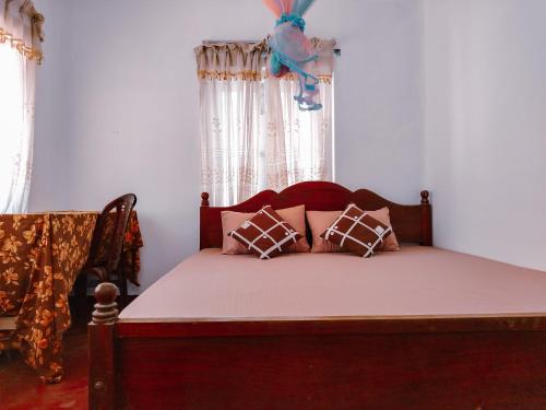 a bedroom with a bed with pillows and a window at Shan Inn Midigama in Midigama East