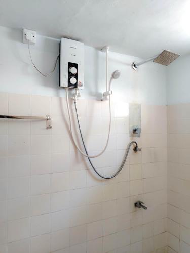 a shower in a bathroom with a hose on the wall at Shan Inn Midigama in Midigama East