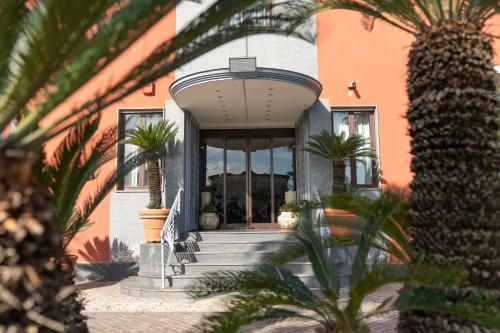 a house with palm trees in front of it at Hotel Paradiso in Lago Patria
