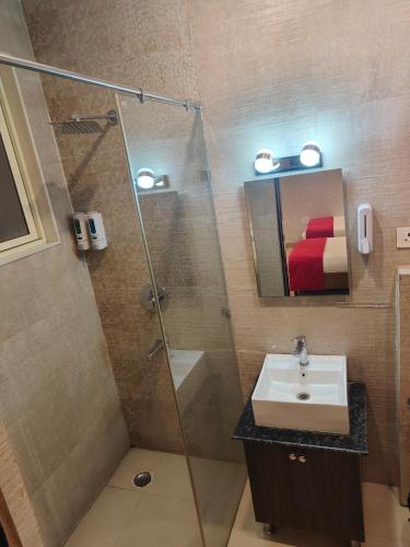 a bathroom with a shower and a sink and a mirror at Crown Ceremonies in Faridabad