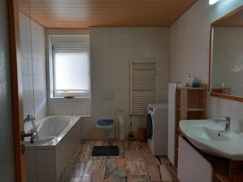 a bathroom with a tub and a sink and a toilet at Ferienwohnung Linke "Grünblick" in Grimma