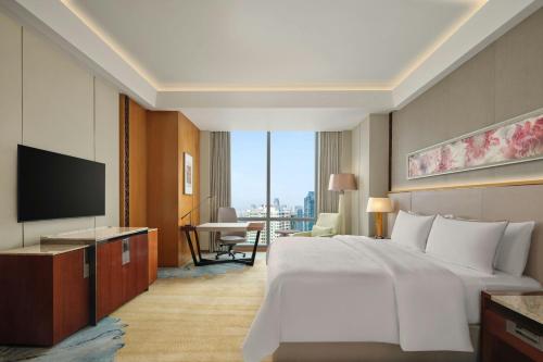 a hotel room with a bed and a television at The Westin Jakarta in Jakarta