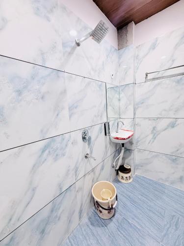 a white bathroom with a shower and a toilet at Hotel Hira Palace in Ujjain