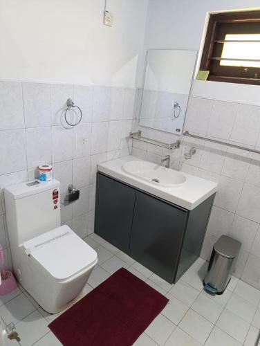 a white bathroom with a toilet and a sink at Zion Haven Villa in Tangalle