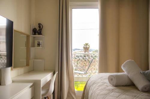 a bedroom with a bed and a desk and a window at El Koulador House in Ialysos