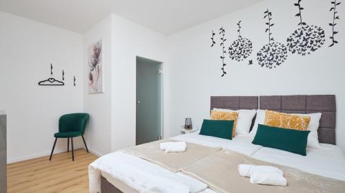 a bedroom with a large bed and a green chair at Villa AD Astra by Villas Guide in Sesvete