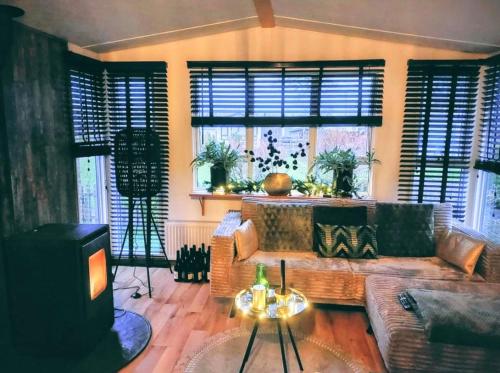 a living room with a couch and a tv at JOY Boutique Chalet Berkhout - Hoorn in De Hulk