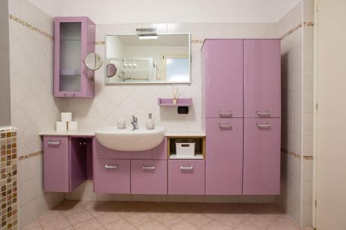 a purple bathroom with a sink and a mirror at Blueberry Villa - Historic Center Lago Maggiore in Luino