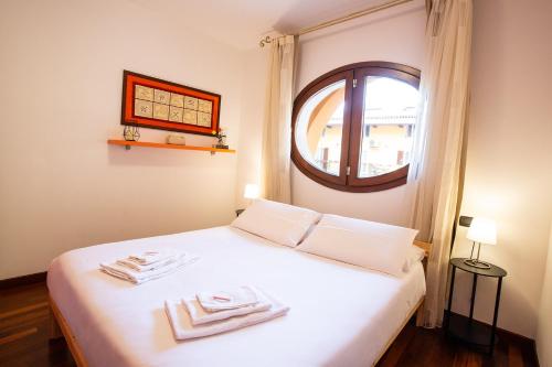 a bedroom with a white bed with a window at Blueberry Villa - Historic Center Lago Maggiore in Luino