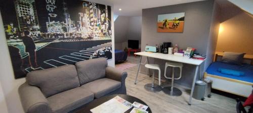 a living room with a couch and a table at Les nichoirs - Appartemment à Vouvray in Vouvray