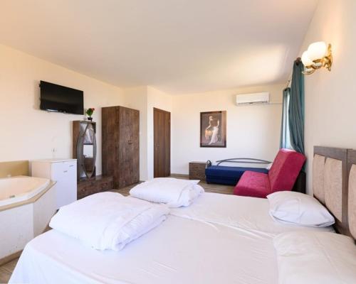 a bedroom with a white bed and a sink at האלפים של הכרמל ומצפה העמקים- וילה ומלונית מול נוף הצפון in Talpiyyot